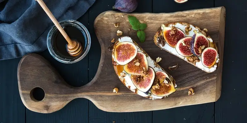 Pão integral torrado com cobertura de nozes de figo doce e queijo camembert